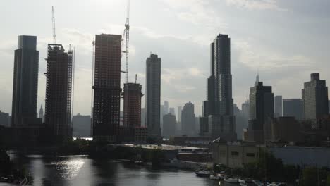 Mientras-El-Sol-De-La-Tarde-Ilumina-Los-Rascacielos-De-Manhattan,-El-Agua-Del-Canal-Del-Río-Brilla-Con-Una-Belleza-Radiante