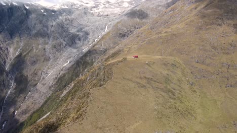Aerial-overview-of-Brewster-Hut-hiking-trek,-reveal-of-Mt-Brewster-peak-and-glacier