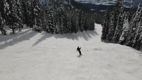 El-Snowboard-Aéreo-Sigue-El-Movimiento-Desde-Un-ángulo-Alto-Con-La-Hermosa-Montana-En-El-Fondo
