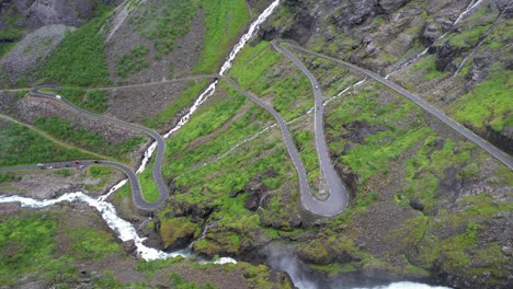 Mountain-waterfall-pours-on-cars-on-the-road-of-trolls