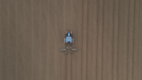 Top-Down-View-Of-Tractor-Cultivating-Rural-Land-For-Seeding-In-Ireland---drone-shot