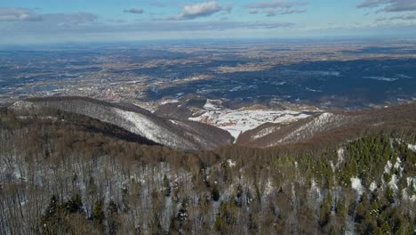 Aerial-4K-drone-footage-of-a-mountain-Ivanščica-and-the-snowy-forest-in-the-winter-time