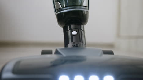 Vertikaler-Staubsauger-Mit-LED-Licht-Auf-Laminatboden,-Der-Sich-In-Richtung-Kamera-Bewegt