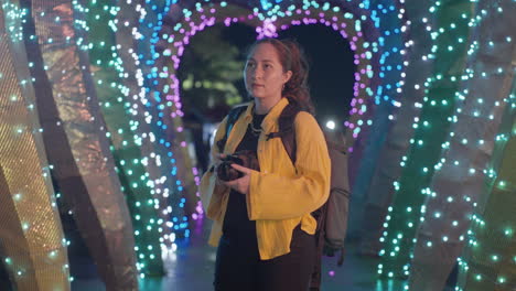 Female-Photographer-Admiring-Beautiful-Multicolored-Lights-At-Night-At-The-Park