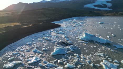 Inclinación-Aérea-Hacia-Arriba-Que-Revela-El-Paisaje-Del-Lago-Glaciar-Con-Iceberg-Disperso