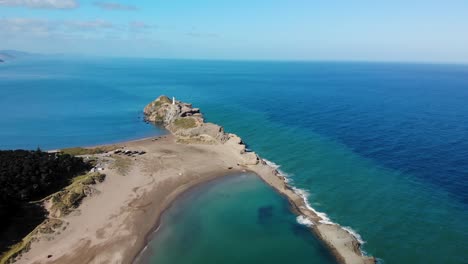 Aerial-overview-of-Castlepoint-lighthouse-located-on-reef,-New-Zealand-landscape
