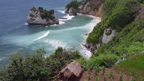 Reveal-shot-of-charming-small-hut-perched-on-a-cliff-at-Sumba,-aerial