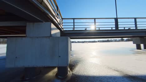 Die-Brücke,-Die-An-Einem-Sonnigen-Sommertag-Vom-Eis-Eines-Zugefrorenen-Flusses-Gefangen-Ist