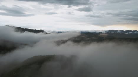 Vuelo-Sobre-La-Nube-De-Niebla-Sobre-El-Terreno-Montañoso-Al-Atardecer-Costa-Rica,-Dron-4k