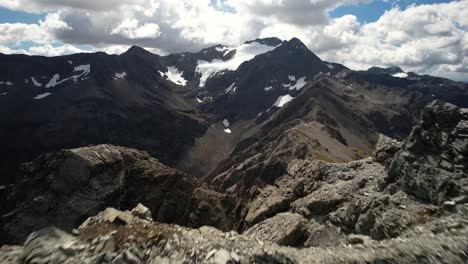 Luftdynamische-Aufnahme-über-Felsigem-Berggipfel,-Enthüllt-Dramatische-Alpenlandschaft