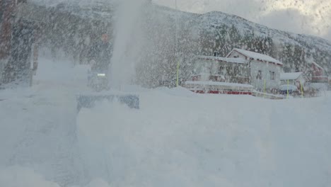 Close-up-shot-of-a-man-using-a-snow-blower-and-throwing-snow-straight-up-front