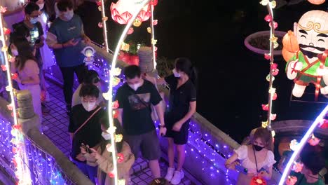 Chinesische-Besucher-Gehen-über-Eine-Mit-Lichtern-Geschmückte-Brücke-Und-Genießen-Während-Des-Mittherbstfestes-Eine-Nächtliche-Laternenshow-Im-Wong-Tai-Sin-Tempel