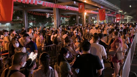 Visitors-go-through-a-long-queue-to-enter-a-nighttime-lantern-show,-which-symbolizes-prosperity-and-good-fortune,-at-the-Wong-Tai-Sin-temple-during-the-Mid-Autumn-Festival-