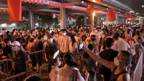 Chinese-vsitors-queue-patiently-in-line-to-enter-a-nighttime-lantern-show,-which-symbolizes-prosperity-and-good-fortune,-at-the-Wong-Tai-Sin-temple-during-the-Mid-Autumn-Festival-