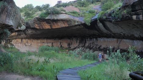 Tourist-walks-path-with-guide-in-Liphofung-Cave-in-northern-Lesotho