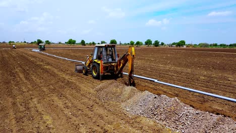 Aerial-Camera-moving-forward-to-excavation-water-pipe-and-large-water-system-underground-at-agricultural-farm-in-India