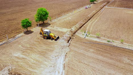 Aerial-view,-Cinematic-view-of-heavy-duty-excavation-machine-working-at-Indian-agricultural-land