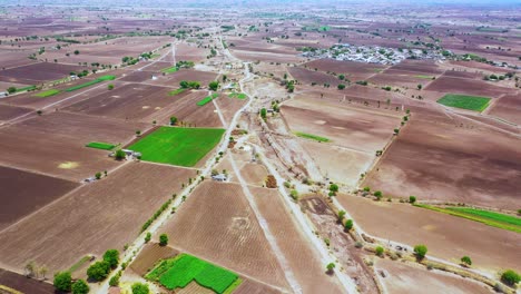 Aerial-camera-moving-above-the-agricultural-farm-land,-village-farming-aerial-view