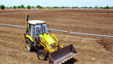 Aerial-follow-shot-of-heavy-duty-excavation-machine-at-Indian-agricultural-land