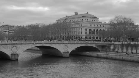 Stunning-Grayscale-View-Of-Seine-River-Beneath-The-Bridge-In-Paris,-France