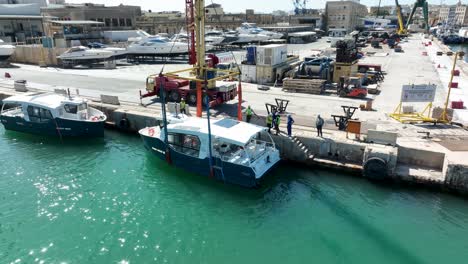 Orbit-Drone-aerial-shot-around-a-boat-that-has-just-been-moved-from-land-to-sea-at-MMH-ship-yard-Malta