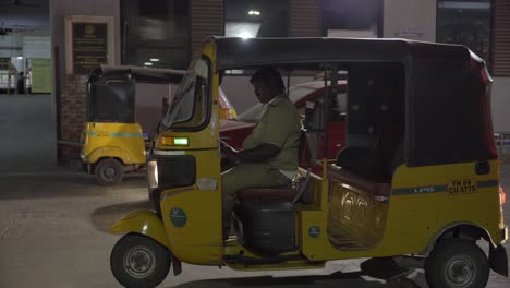 LPG-Autorickshaw-driver-waiting-for-the-customer-outside-Chennai-bus-station-building,-India