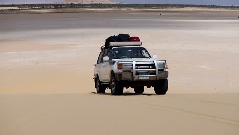 Camp-car-walking-on-the-sand-under-the-hot-sky-in-the-desert---pan-right