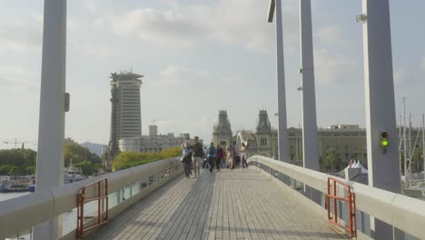 Gente-Caminando-Sobre-El-Puente-Rambla-De-Mar-En-Barcelona,-España-En-Un-Día-Soleado