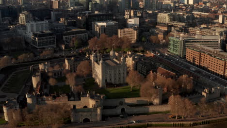 Circling-aerial-shot-around-Tower-of-London-panning-up-revealing-modern-City-of-London-skyscrapers