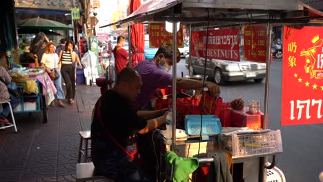 Vendors-pack-and-display-Chestnuts,-prepare-for-business,-and-await-customers-at-the-famous-Yaowarat-Chinatown,-Bangkok,-Thailand