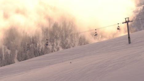 Ski-ift-running-during-early-morning-sunrise-in-skiing-center-in-Myrkdalen-Norway---Idyllic-moody-clip-with-a-few-skiers-passing-by-during-golden-hour