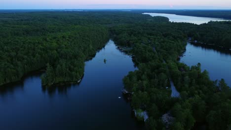 Aerial-view-of-Ontario-lake-with-waterfront-cottages-along-peninsula-at-blue-hour