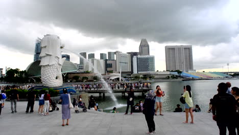 Una-Vista-Amplia-De-La-Atracción-Turística-De-Singapur,-El-Merlion,-Con-El-Edificio-Y-La-Bahía-Al-Fondo.