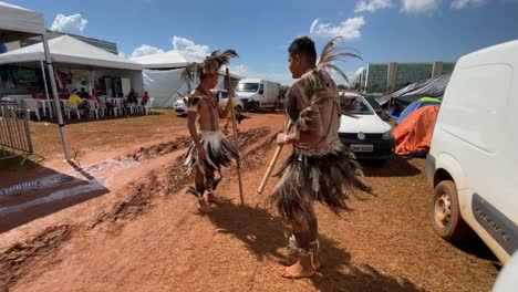 At-a-local-festival-for-indigenous-amazon-people,-two-men-in-traditional-feather-clothing-are-dancing