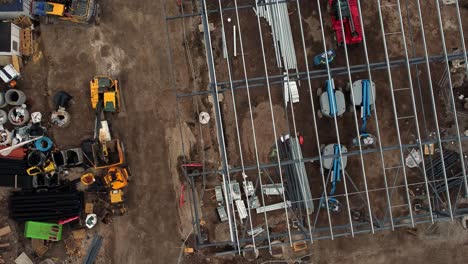 ALDI-supermarket-construction-building-site-aerial-view-top-down-orbit-above-industrial-framework-development,-UK