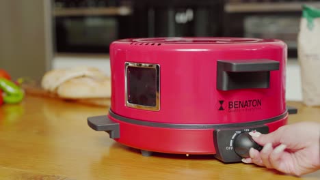 A-hand-turns-the-adjustment-knob-of-the-electric-bread-maker-machine