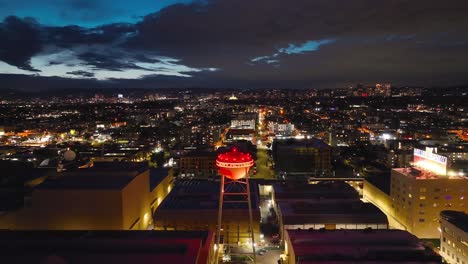 Sony-Pictures-Studio-famous-water-tower-at-nighttime---rising-aerial-reveal-of-the-city