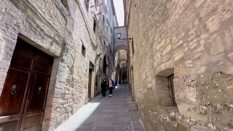 Elder-tourist-walking-down-narrow-street-of-Italian-city,-static-view