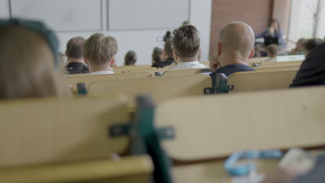Students-Seating-Inside-Lecture-Theatre-Listening-To-Teacher