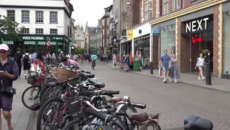 People-cycle-and-walk-along-Sidney-Street-in-Cambridge,-UK