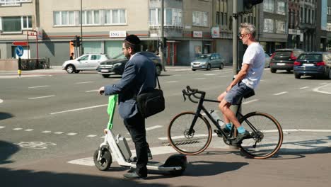 Jewish-man-with-Kippah-hat-on-electric-scooter-waiting-at-crossroad-in-the-Antwerp-diamond-district-Belgium