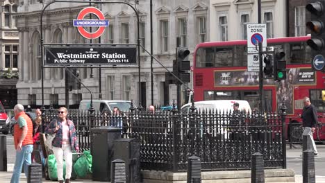 People-walk-past-Westminster-Underground-entrance-along-Whitehall-in-London,-UK