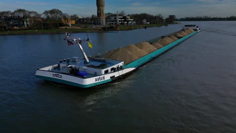 Aerial-view-of-sand-loaded-general-cargo-ship-Avelie-sailing-through-river-Oude-Mass