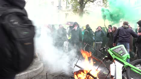 Rioter-holds-sign-in-front-of-burning-bike-in-Paris,-France