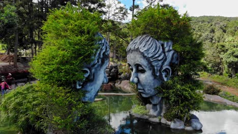 Aerial-drone-shot-of-gray-head-sculptures-at-Tunnel-Clay-Park,-Dalat-City,-Vietnam