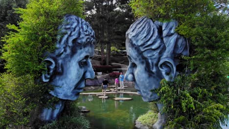 Aerial-drone-shot-of-head-sculptures-at-Tunnel-Clay-Park,-Dalat-City,-Vietnam