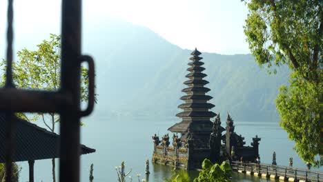 Slow-motion-panning-shot-of-Pura-Segara-Ulun-Danu-Batur-a-historical-temple-at-volcanic-lake-batur-on-a-sunny-day-during-the-beautiful-summer-trip-through-bali-indonesia