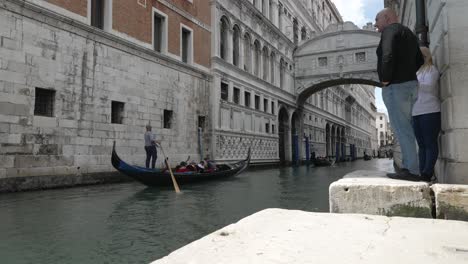 Touristen-Beobachten-Gondeln,-Die-An-Der-Seufzerbrücke-Am-Rio-Del-Palazzo-In-Venedig-Vorbeifahren