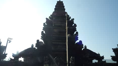 Ascending-tilt-up-shot-of-the-majestic-Pura-Ulun-Danu-temple-on-the-lake-in-bali-indonesia-during-a-beautiful-golden-hour-morning