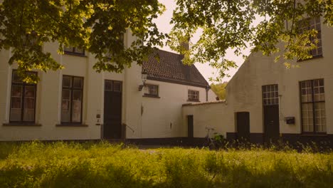 White-houses-in-the-Beguinage-religious-convent-in-Bruges,-Flanders,-Belgium